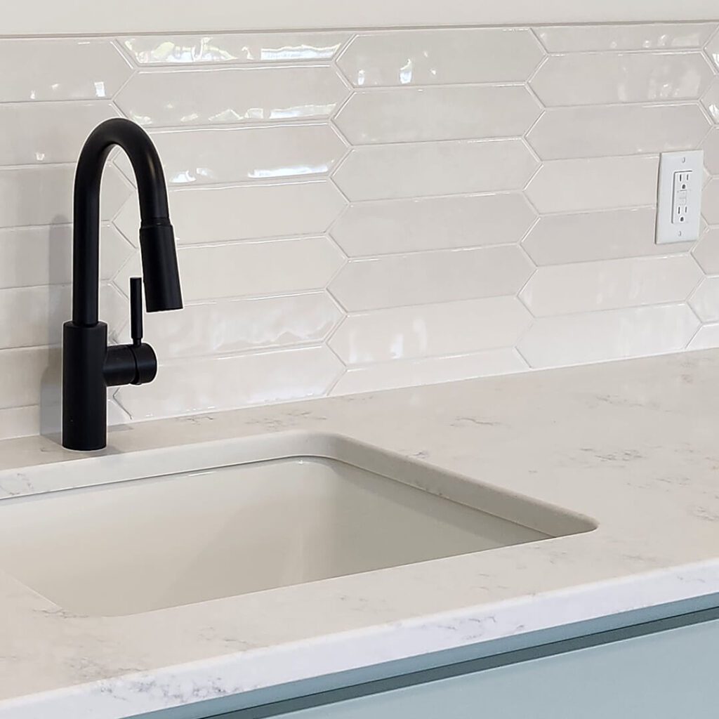 Modern white stacked picket tile backsplash with black faucet, expertly installed by Esox Custom Tiling in Madison, WI—ideal for contemporary kitchens.
